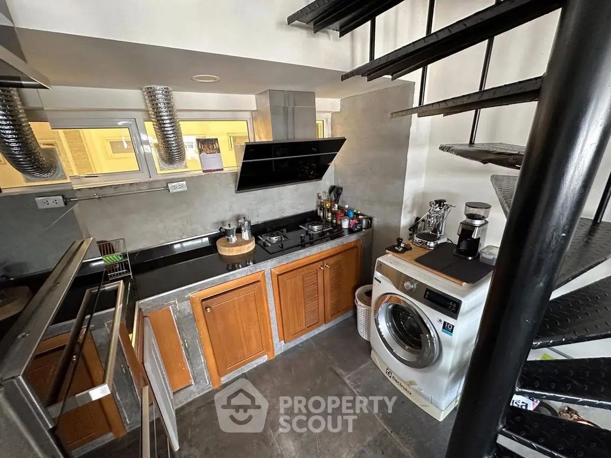 Modern compact kitchen with spiral staircase and washing machine