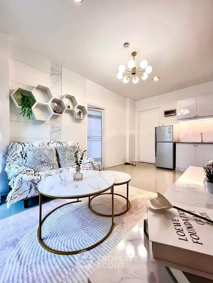 Modern living room with stylish decor, marble coffee table, and open kitchen layout.