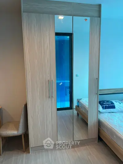 Modern bedroom with mirrored wardrobe and cozy bed in stylish apartment.