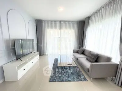 Modern living room with sleek furniture and large windows for natural light.