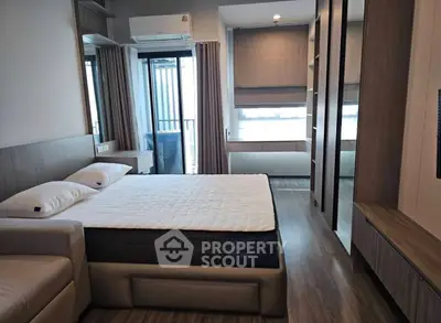 Modern bedroom with stylish decor and large windows offering natural light