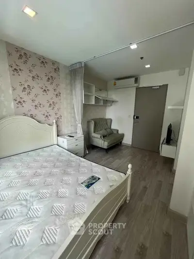 Charming bedroom with floral wallpaper and cozy seating in modern apartment