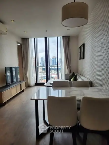 Modern living room with city view, stylish furniture, and natural light.