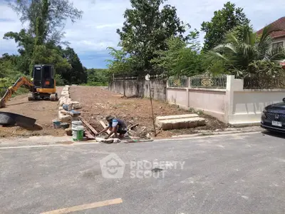 Residential construction site with machinery and worker, potential for new home development.