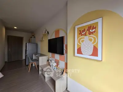 Modern living room with stylish decor and wall art, featuring a mounted TV and sleek furniture.