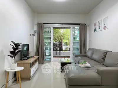 Modern living room with sleek furniture and large window view.