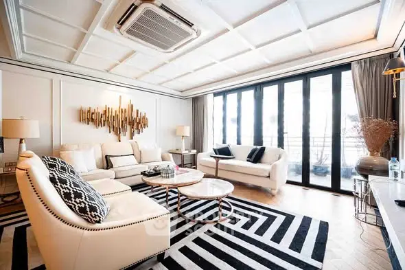 Luxurious living room with elegant decor and large windows for natural light.