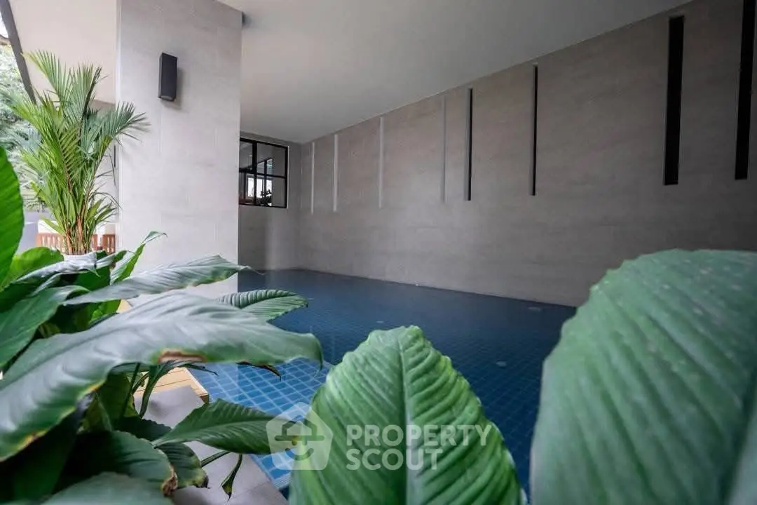 Modern indoor pool area with lush greenery and sleek design