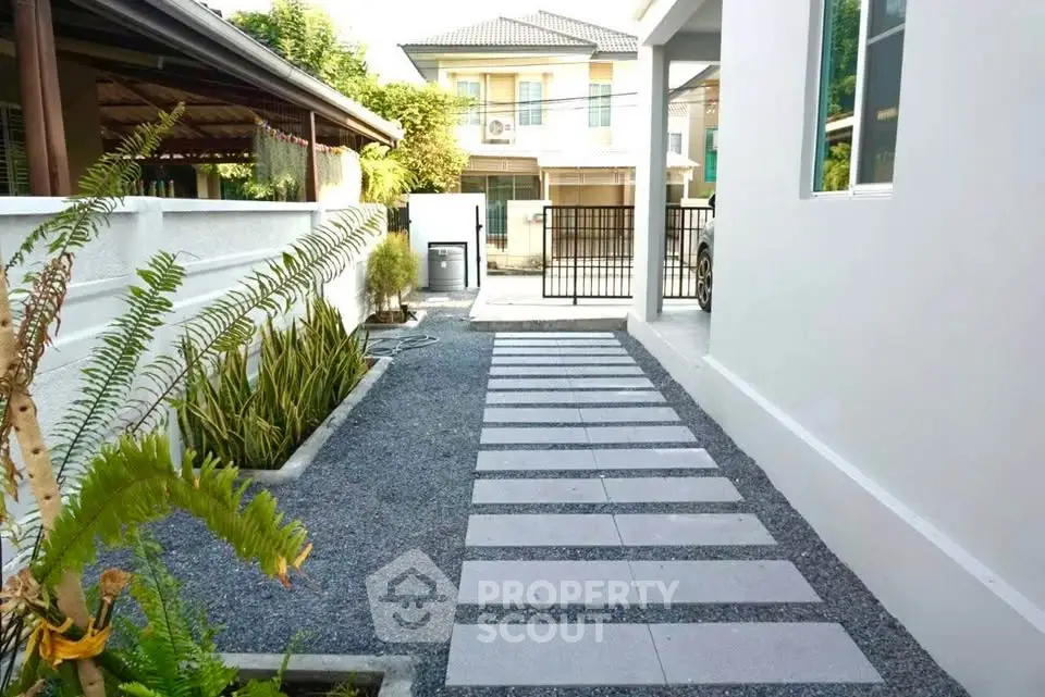 Modern house exterior with sleek pathway and landscaped garden