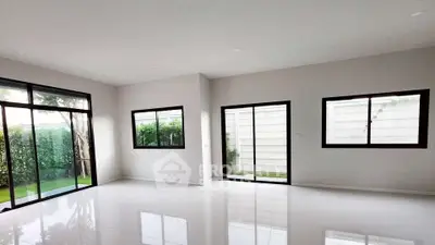Spacious empty living room with large windows and garden view, perfect for customization.