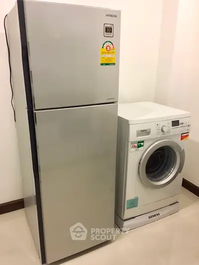 Modern kitchen appliances featuring a sleek fridge and efficient washing machine.