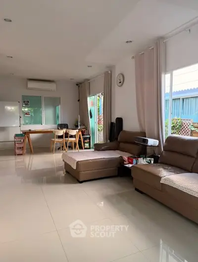 Spacious living room with modern furniture and large windows offering natural light.