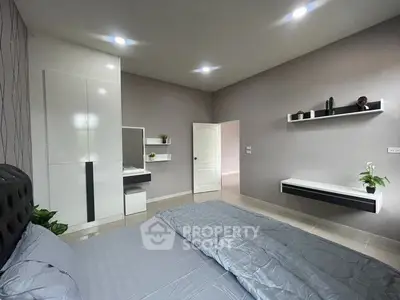 Modern bedroom with sleek design, featuring built-in wardrobe and stylish decor.