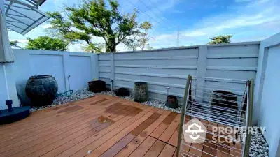 Spacious outdoor patio with wooden deck and decorative pots, perfect for relaxation and entertaining.