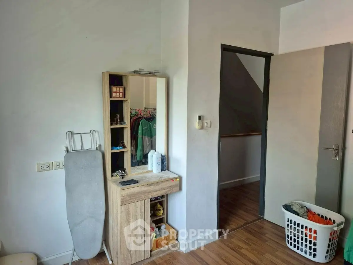 Cozy bedroom with wooden flooring and modern vanity, perfect for a stylish living space.