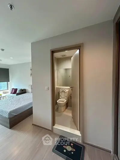 Modern bedroom with ensuite bathroom featuring sleek design and cozy ambiance.
