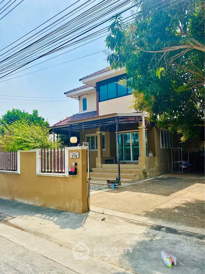 Charming two-story house with spacious driveway and lush greenery, perfect for family living.