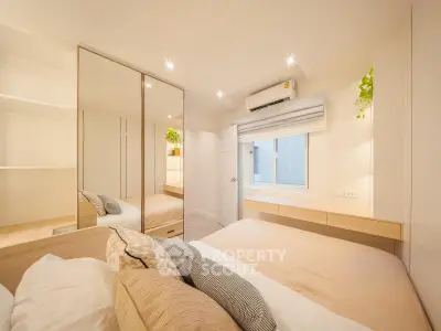 Modern bedroom with cozy decor and mirrored wardrobe in a stylish apartment