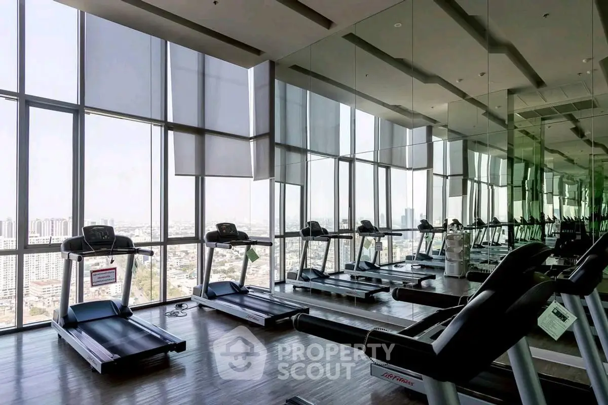 Spacious modern gym with city view and multiple treadmills.