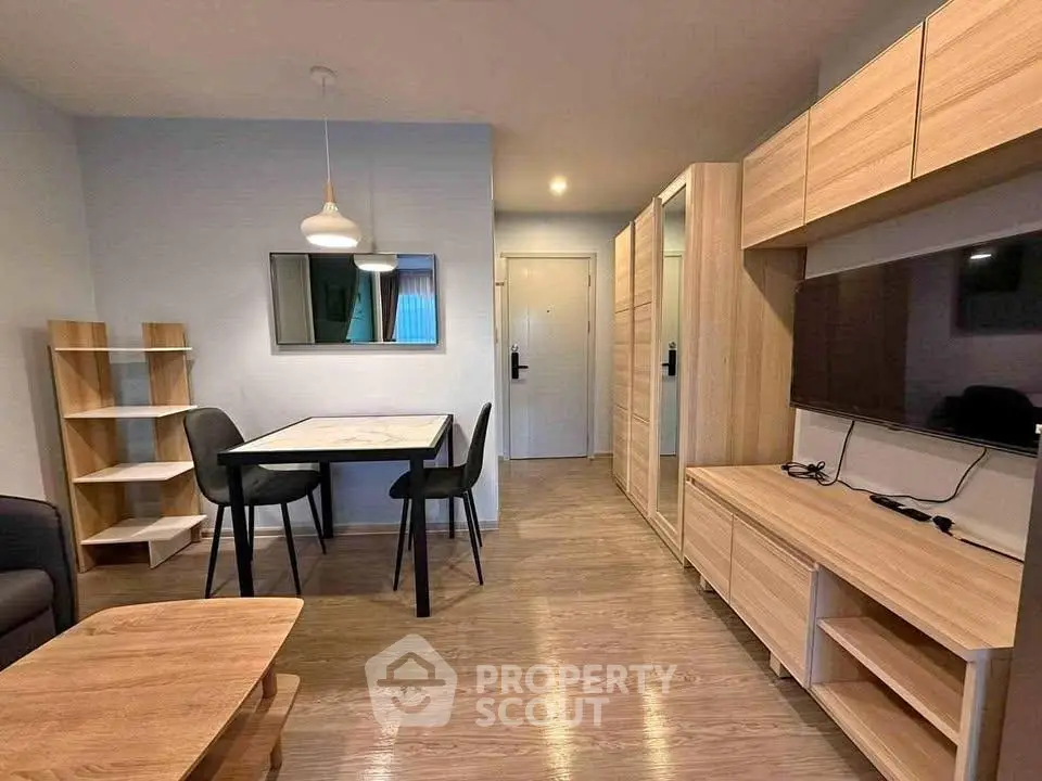 Modern living room with sleek furniture and wooden flooring, featuring a dining area and TV unit.