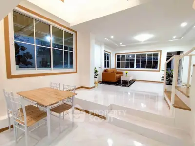 Spacious modern living room with elegant dining area and large windows.