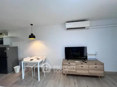 Modern living room with sleek furniture and air conditioning, featuring a stylish dining area and entertainment setup.