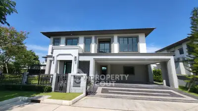 Luxurious modern two-story house with spacious driveway and lush greenery