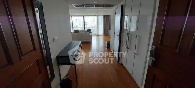 Spacious modern living room with wooden flooring and city view, perfect for urban living.