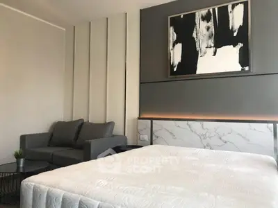 Modern bedroom with stylish decor and cozy seating area, perfect for relaxation.
