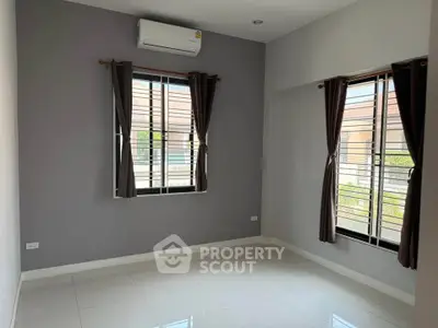 Spacious empty room with large windows and air conditioning, perfect for customization.