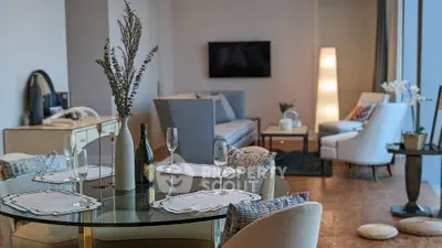 Elegant living room with stylish decor and dining area, featuring modern furniture and ambient lighting.