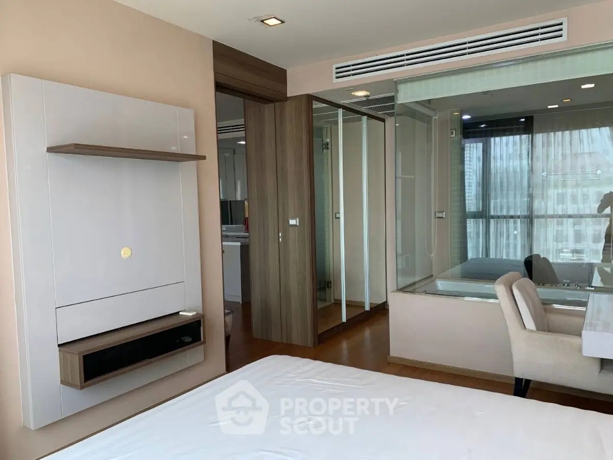 Modern bedroom with glass partition and sleek furniture in a stylish apartment