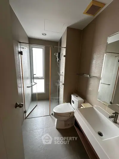 Modern bathroom with glass shower and sleek fixtures in a contemporary apartment.
