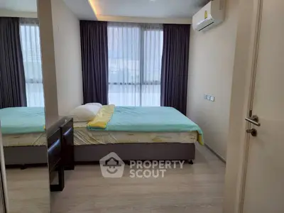 Modern bedroom with large window, air conditioning, and stylish decor in a contemporary apartment.