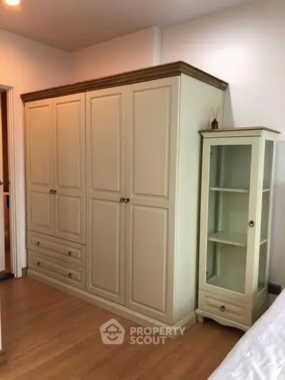 Spacious bedroom with elegant wardrobe and glass cabinet
