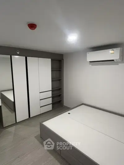 Modern minimalist bedroom with built-in wardrobe and air conditioning unit