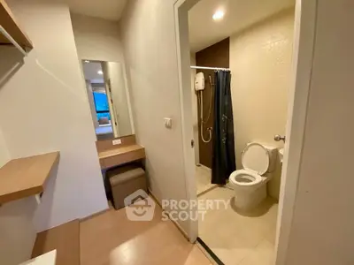 Modern apartment bathroom with shower and vanity area, featuring sleek design and neutral tones.