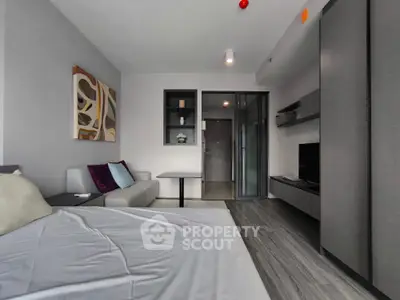 Modern studio apartment with sleek design and stylish furnishings, featuring a cozy bed and contemporary decor.