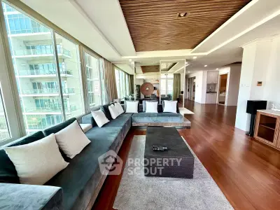 Luxurious modern living room with panoramic windows and elegant wooden ceiling design.