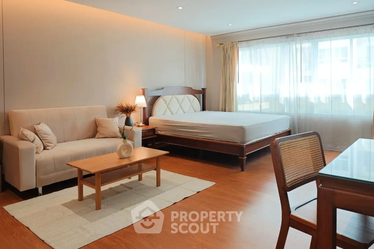 Spacious studio apartment with elegant wooden flooring and natural light