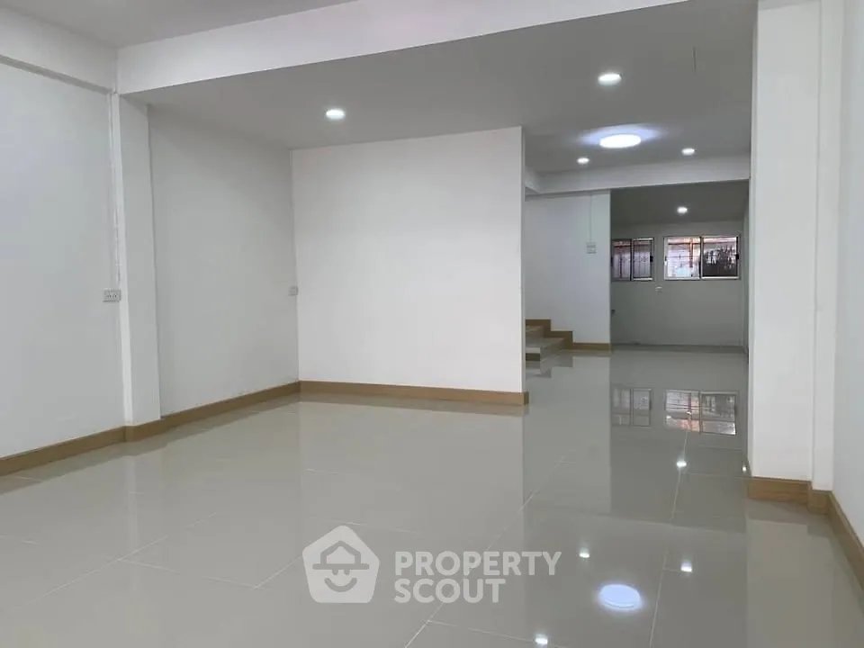 Spacious open-plan living area with modern tile flooring and ample natural light.