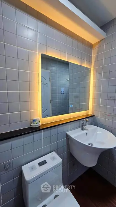 Modern bathroom with illuminated mirror and sleek fixtures