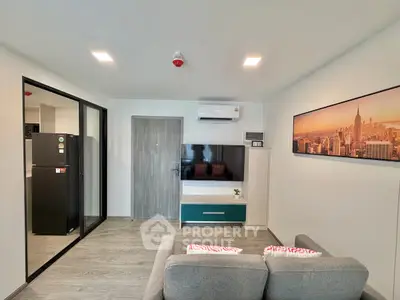Modern living room with sleek design, featuring a wall-mounted TV, air conditioning, and stylish decor.