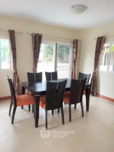 Elegant dining area with modern table and chairs, bright natural light, and stylish curtains.