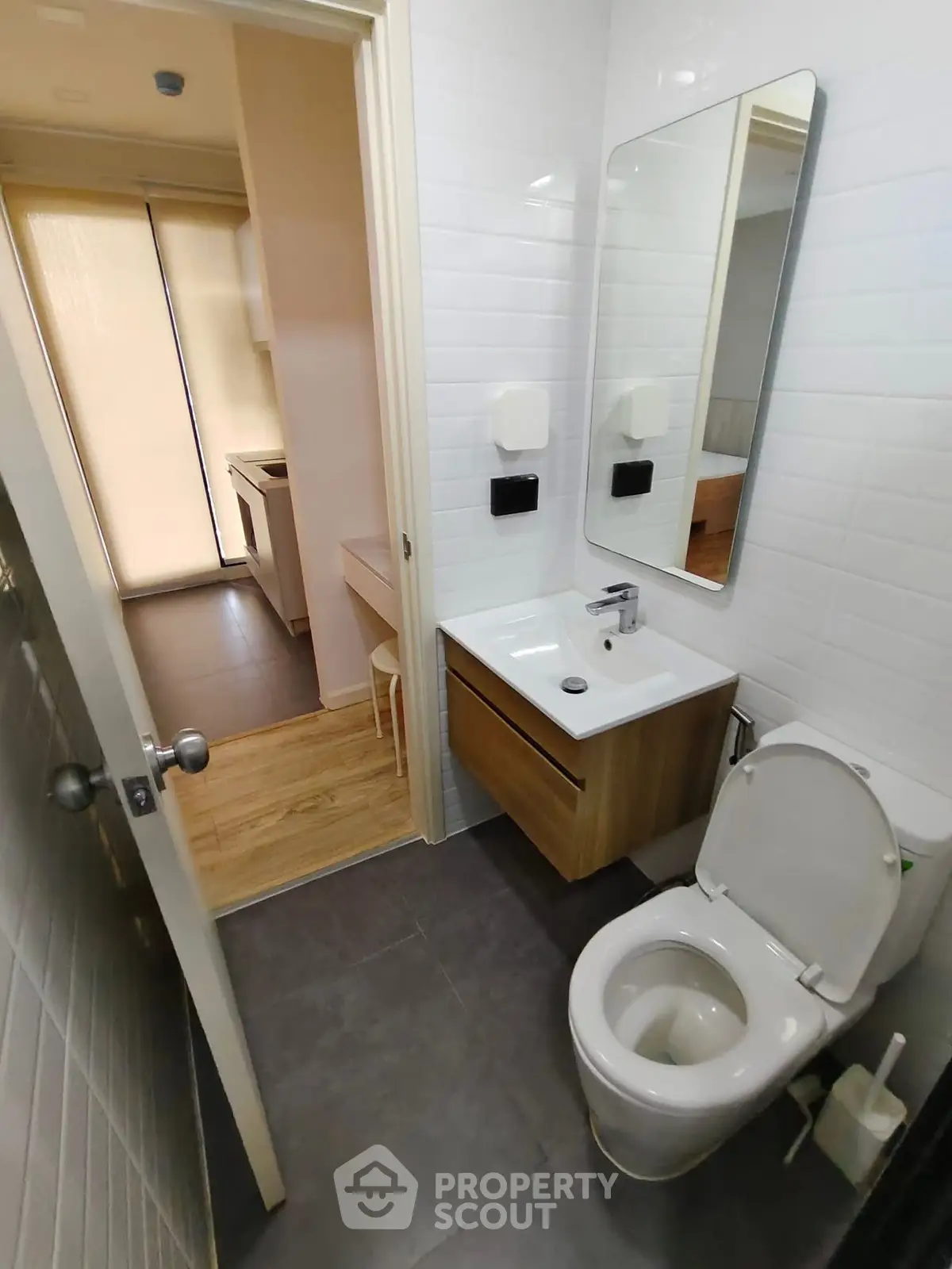 Modern bathroom with sleek fixtures and a view into a cozy kitchen area.