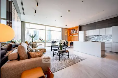 Luxurious open-layout living room with modern kitchen and stunning city view.