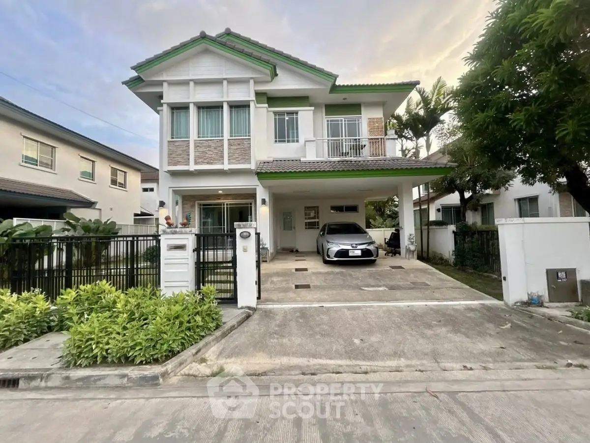 Charming two-story house with driveway and lush greenery in a serene neighborhood.