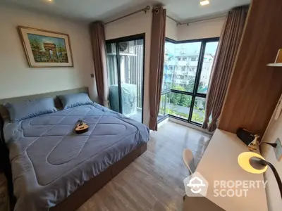 Modern bedroom with large windows and balcony view, featuring stylish decor and natural light.