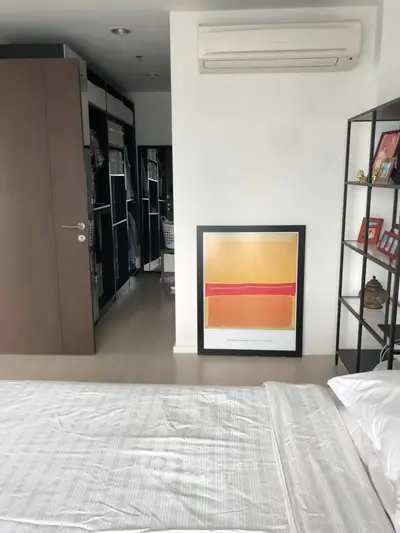 Modern bedroom with stylish decor and spacious walk-in closet, featuring sleek air conditioning unit.