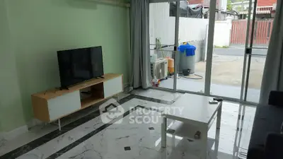 Modern living room with sleek marble flooring and large glass doors opening to a patio.
